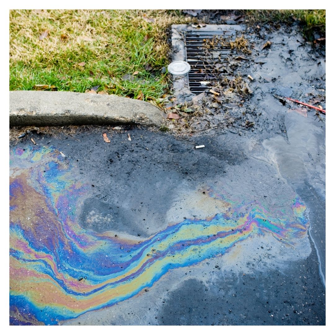 An oil spill next to a drain